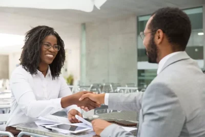 man and woman sitting and shaking hands